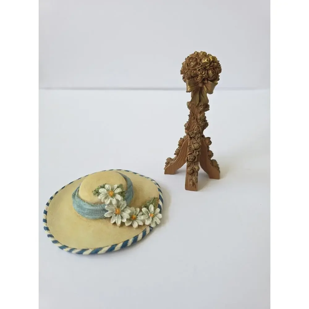 SANDY LYNAM CLOUGH COLLECT. SUZETTE DAISY BLUE STRIPE RESIN HAT WITH ROSE STAND